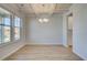 Elegant dining room with coffered ceiling, chandelier, large windows, and light hardwood floors at 2436 Cadenza Cir, Dacula, GA 30019