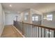 Bright hallway with wood floors and decorative railing leads to the upper level at 2436 Cadenza Cir, Dacula, GA 30019