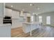 Modern white kitchen with a large center island, stainless steel appliances, and pendant lighting at 2436 Cadenza Cir, Dacula, GA 30019