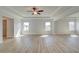 Spacious living room with wood-look floors, light-colored walls, tray ceiling, and a ceiling fan at 2436 Cadenza Cir, Dacula, GA 30019