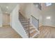 Stylish staircase with wood treads, white risers, black iron spindles, and light hardwood flooring at 2436 Cadenza Cir, Dacula, GA 30019