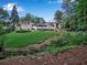 Expansive backyard features a bridge, lush landscaping, and a glimpse of the home's elegant design at 3625 Tuxedo Nw Rd, Atlanta, GA 30305