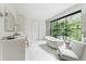 Bright bathroom with marble countertop vanity, stylish fixtures, and a large window overlooking the backyard at 3625 Tuxedo Nw Rd, Atlanta, GA 30305