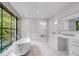 Bathroom with marble-style soaking tub, double vanity, and large window at 3625 Tuxedo Nw Rd, Atlanta, GA 30305