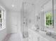 Bright, all-white bathroom with a glass shower, marble countertop, and decorative tile floor at 3625 Tuxedo Nw Rd, Atlanta, GA 30305
