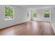 Bright bedroom features hardwood floors, white trim, and three windows overlooking the landscaped exterior at 3625 Tuxedo Nw Rd, Atlanta, GA 30305