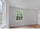 Bright bedroom features hardwood floors, white trim, and two windows overlooking the landscaped exterior at 3625 Tuxedo Nw Rd, Atlanta, GA 30305