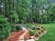 Peaceful garden with a small bridge over a creek surrounded by lush greenery and colorful flowers at 3625 Tuxedo Nw Rd, Atlanta, GA 30305