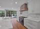 Gourmet kitchen with black and gold stove, white cabinets, marble countertops, and views of the outdoor pool at 3625 Tuxedo Nw Rd, Atlanta, GA 30305