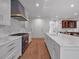 Spacious kitchen with marble countertops, white cabinetry, stainless appliances, and wood flooring at 3625 Tuxedo Nw Rd, Atlanta, GA 30305