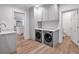 Functional laundry room with modern washer and dryer, light cabinetry, and sink area at 3625 Tuxedo Nw Rd, Atlanta, GA 30305