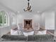Cozy living room with brick fireplace, stylish chandelier, comfortable seating, and natural light at 3625 Tuxedo Nw Rd, Atlanta, GA 30305