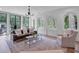 Bright living room featuring large windows, a modern chandelier, and stylish decor at 3625 Tuxedo Nw Rd, Atlanta, GA 30305