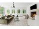 Sun-drenched living room boasts a fireplace, stylish chandelier, and large arched windows with green views at 3625 Tuxedo Nw Rd, Atlanta, GA 30305