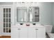 Bathroom with double sink vanity and modern fixtures, plus a shower in the mirror's reflection at 11 Pine St, Covington, GA 30014