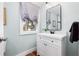 Bathroom featuring a sink with a black faucet and decor, a mirror and a window at 11 Pine St, Covington, GA 30014