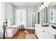 Bright bathroom featuring a tub, a double sink vanity, and modern lighting at 11 Pine St, Covington, GA 30014