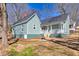 Charming two-story home with teal siding, a covered porch, and mature trees providing shade, creating an inviting curb appeal at 11 Pine St, Covington, GA 30014