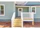 Exterior view of the front porch with wooden stairs and a front door with a wreath at 11 Pine St, Covington, GA 30014