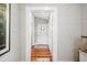 Hallway view of a beautiful home with white wooden walls and hardwood floors leading to the front door at 11 Pine St, Covington, GA 30014