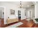 Hallway with hardwood floors, white shiplap walls, decorative artwork, and entryways to the bedrooms, creating a cozy ambiance at 11 Pine St, Covington, GA 30014