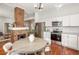 Modern kitchen with white cabinets, stainless steel appliances, granite countertops, and a brick fireplace for added charm at 11 Pine St, Covington, GA 30014
