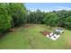Expansive backyard featuring a patio, garden beds, a white utility shed and beautiful, mature shade trees at 11415 Hutcheson Ferry Rd, Chattahoochee Hills, GA 30268