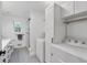 Bright bathroom featuring white cabinets, gray hexagon floor tiles, and white washer/dryer at 11415 Hutcheson Ferry Rd, Chattahoochee Hills, GA 30268