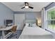 Bedroom with desk, chair, a bed with a blue and white pillow, and a window at 11415 Hutcheson Ferry Rd, Chattahoochee Hills, GA 30268