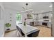 Bright dining area featuring an adjacent, modern kitchen with stainless steel appliances and gray cabinets and an open layout at 11415 Hutcheson Ferry Rd, Chattahoochee Hills, GA 30268