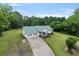Aerial view of a well-maintained home featuring a new, green roof, and an extra-long driveway at 11415 Hutcheson Ferry Rd, Chattahoochee Hills, GA 30268