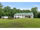 Spacious backyard featuring a well-maintained green lawn and views of the charming, white-sided home at 11415 Hutcheson Ferry Rd, Chattahoochee Hills, GA 30268