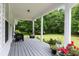 Inviting front porch offers a relaxing outdoor space with seating, planters, and serene views of the surrounding greenery at 11415 Hutcheson Ferry Rd, Chattahoochee Hills, GA 30268