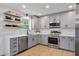 This kitchen features gray cabinets, stainless steel appliances and floating wooden shelves at 11415 Hutcheson Ferry Rd, Chattahoochee Hills, GA 30268