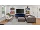 Bright living room with comfortable seating, open shelving, and a large TV, perfect for relaxation and entertainment at 11415 Hutcheson Ferry Rd, Chattahoochee Hills, GA 30268