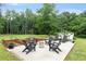 Outdoor patio with modern Adirondack seating, fire pit, and manicured landscaping create an inviting space at 11415 Hutcheson Ferry Rd, Chattahoochee Hills, GA 30268