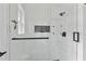 A close up of the shower featuring white subway tiles, a hexagon tiled niche, and glass doors at 11415 Hutcheson Ferry Rd, Chattahoochee Hills, GA 30268