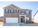 Traditional brick home with a manicured lawn and attached garage at 11562 Creekstone Rd, Hampton, GA 30228