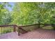 A spacious wooden deck with railings surrounded by lush trees and greenery at 1265 Woodland Se Ave, Atlanta, GA 30316
