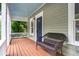 Inviting covered front porch with a wicker bench and painted ceiling for relaxing outdoors at 1265 Woodland Se Ave, Atlanta, GA 30316