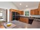 Kitchen with wood cabinets, black appliances, stone countertops, and an island with barstool seating at 1265 Woodland Se Ave, Atlanta, GA 30316