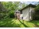 Back exterior with stairs to a deck and verdant lawn, surrounded by trees for privacy at 410 Lima Ct, Woodstock, GA 30188