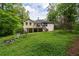 Spacious backyard with lush greenery, a deck, and the rear of the house, perfect for outdoor living at 410 Lima Ct, Woodstock, GA 30188