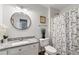 Stylish bathroom with modern vanity, round mirror, and butterfly-themed shower curtain at 410 Lima Ct, Woodstock, GA 30188