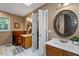 Dual sink bathroom with decorative mirrors, tile floors, and wooden cabinets at 410 Lima Ct, Woodstock, GA 30188