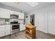 Well-lit kitchen with stainless steel appliances, light countertops, and a wooden center island on wood-look flooring at 410 Lima Ct, Woodstock, GA 30188