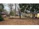 Large wooded lot of yellow single-story home showing undeveloped backyard and outbuildings at 4622 Dogwood Rd, Pine Lake, GA 30072