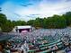 Outdoor amphitheater with a large stage and tiered seating filled with concert attendees surrounded by green trees at 100 Sheridan Dr, Atlanta, GA 30305