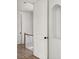 Hallway featuring an open white door, wood floors, staircase and an architectural niche at 100 Sheridan Dr, Atlanta, GA 30305