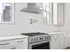 Modern kitchen detail featuring a stainless steel oven and range, marble countertops, and white tiled backsplash at 100 Sheridan Dr, Atlanta, GA 30305